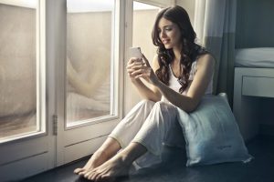 woman at window with phone image