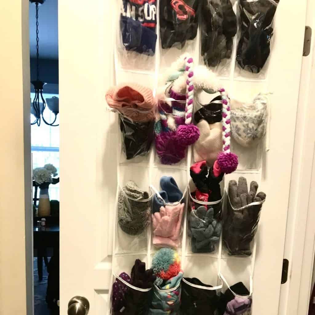 turning closet into mudroom with shoe storage pouches on the door holding gloves and hats