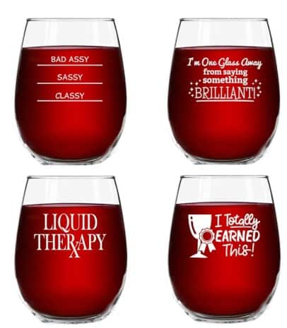 four stemless wine glasses with white writing on them.