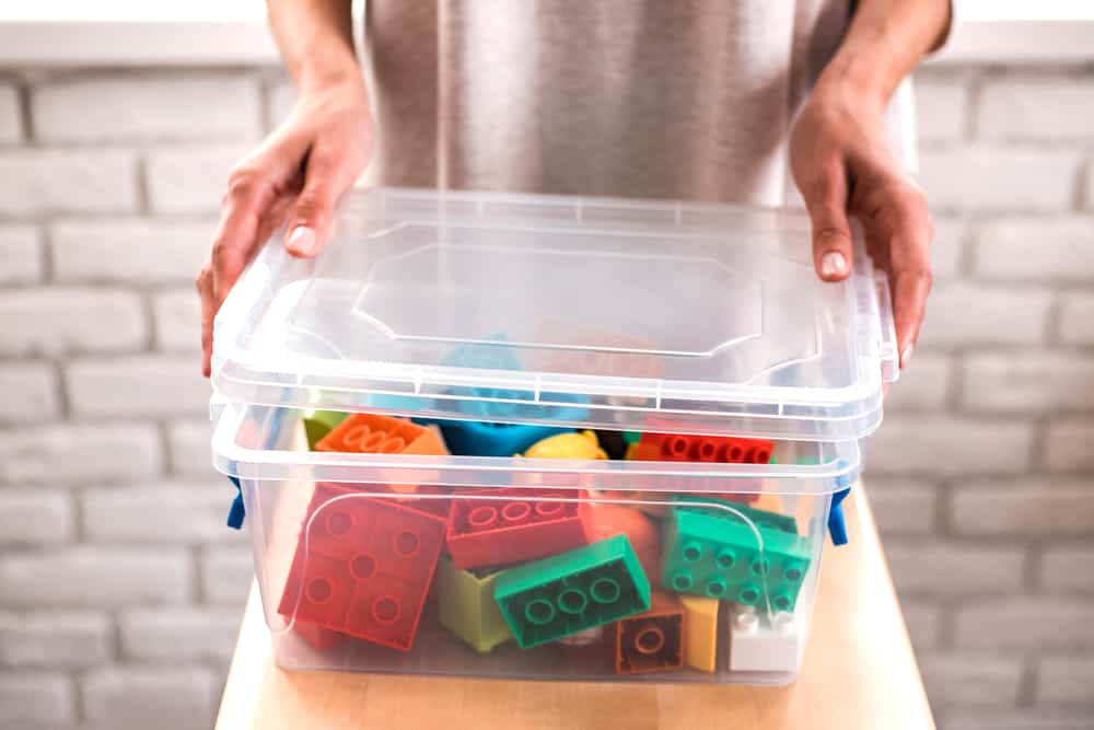 clear storage bin being filled with legos