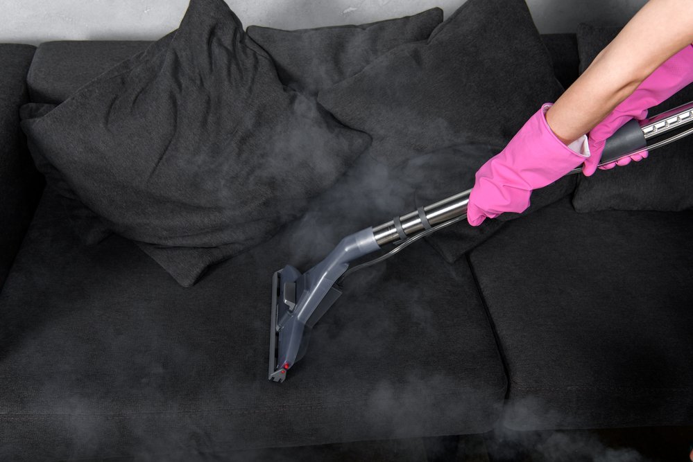 dirty black couch being cleaned with steam cleaner