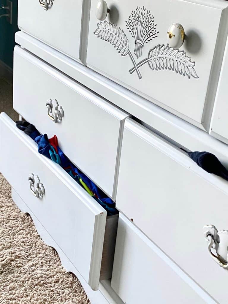 things hanging out of white dresser drawers