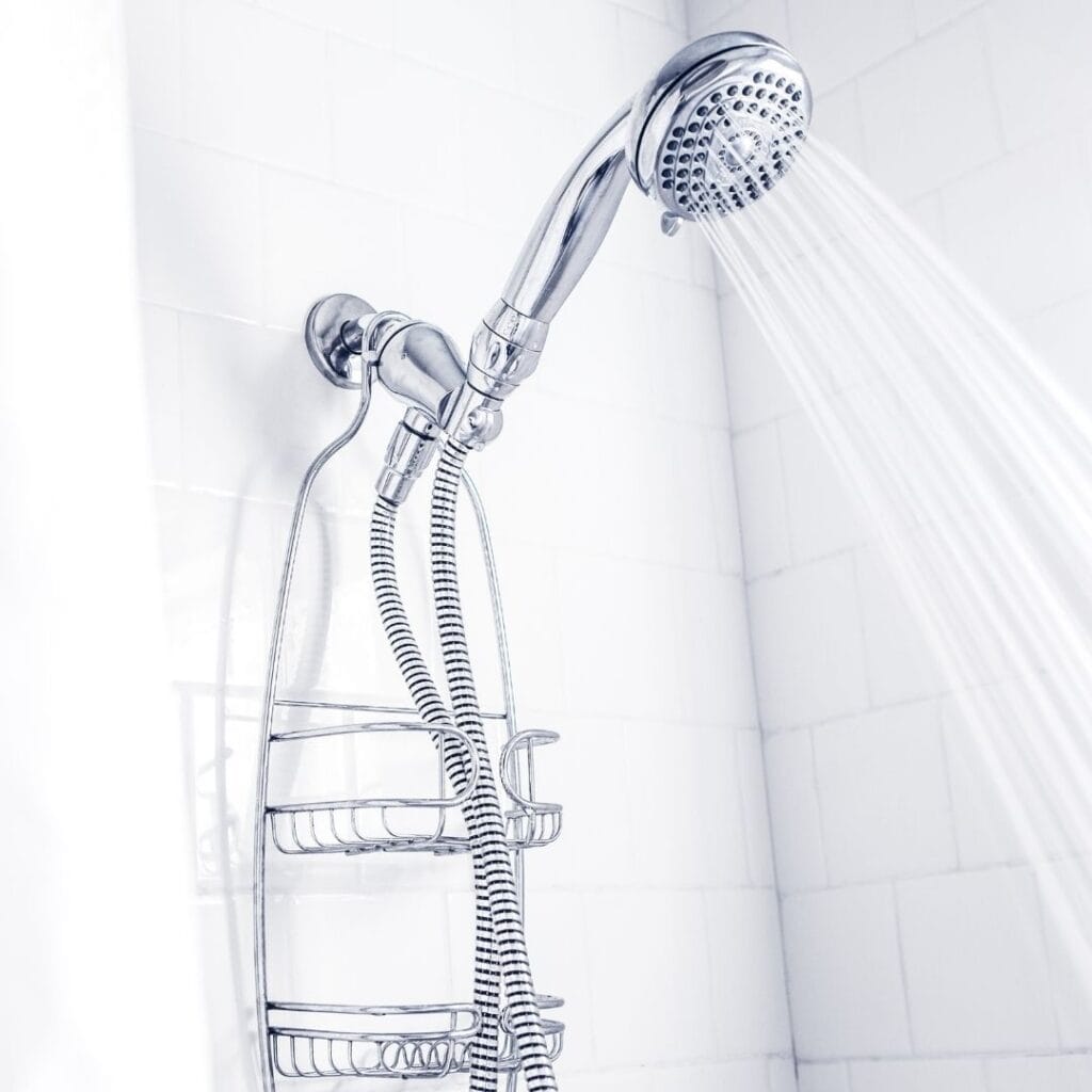 shower head spraying water in a white shower how to clean shower head without vinegar