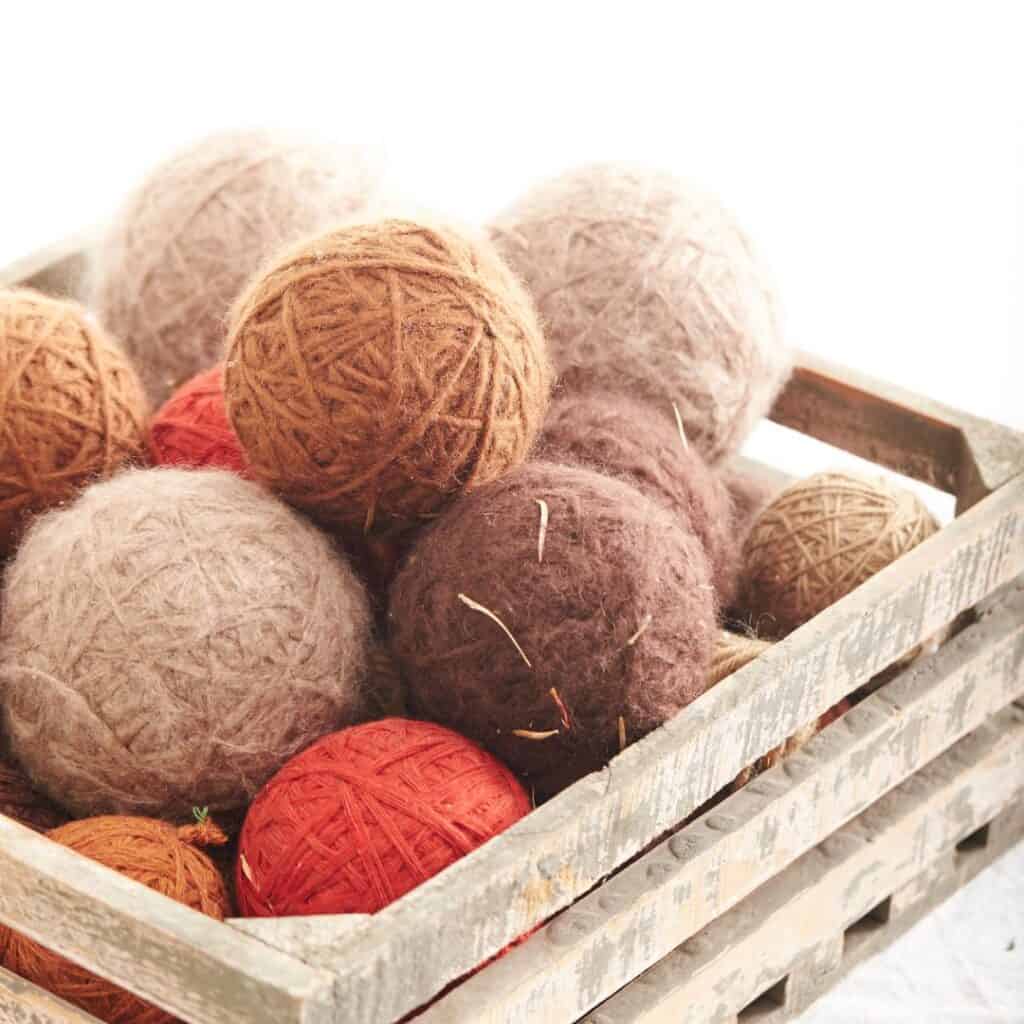 multi colored wool dryer balls in a wooden crate
