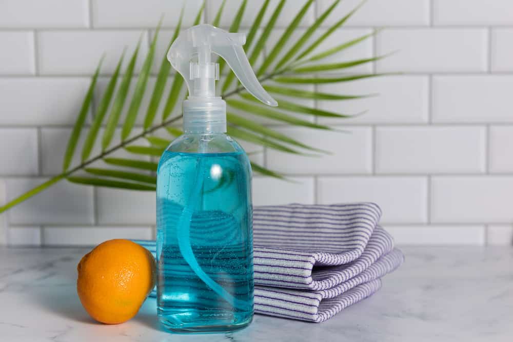 plastic spray bottle near and orange and a towel for how to clean a spray bottle post